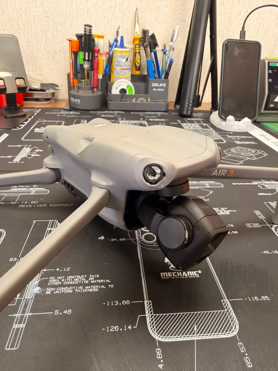DJI Air 3 en la mesa de trabajo de TECDJI PERÚ con el eje del gimbal dañado antes de su reparación