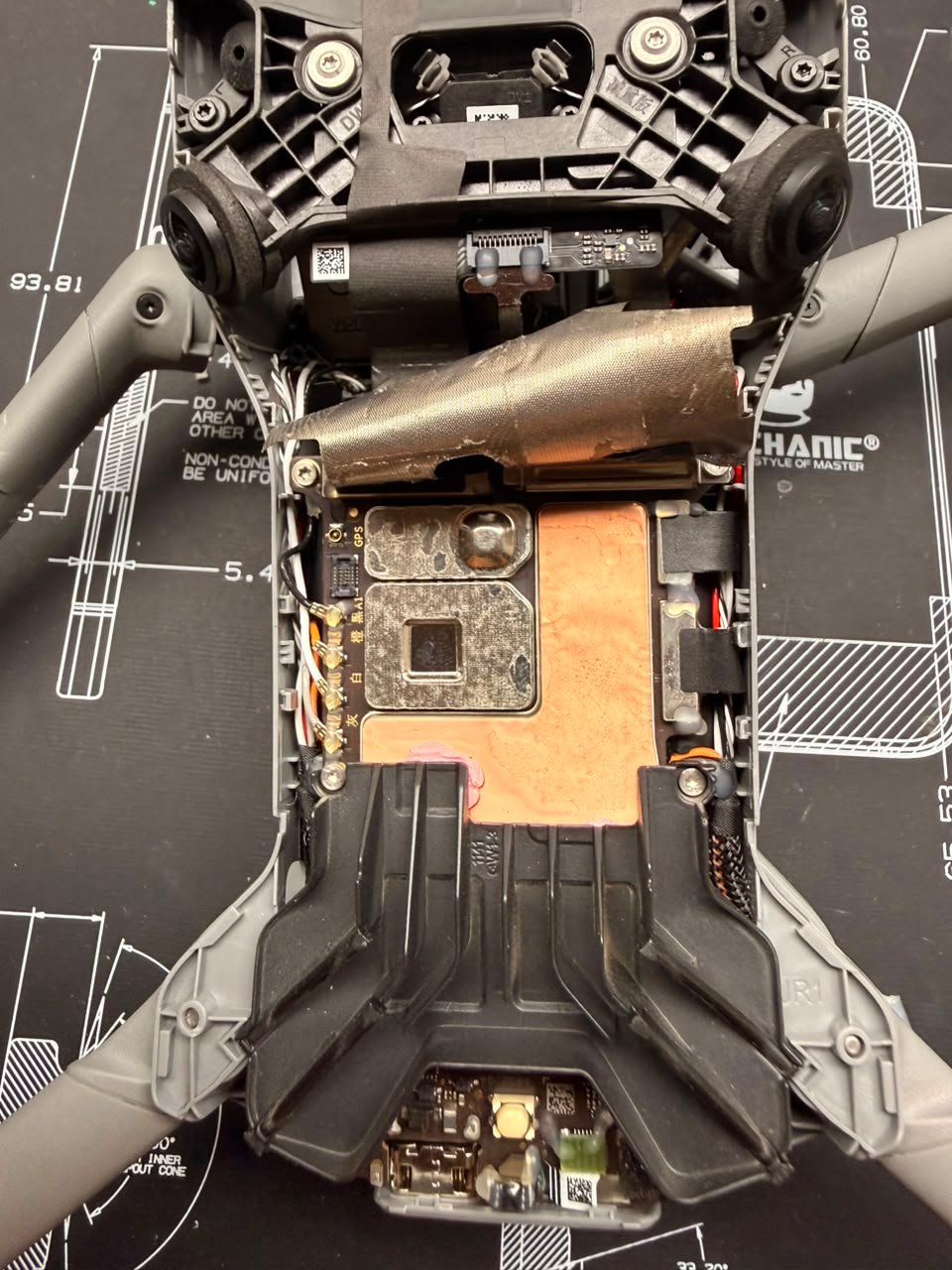 Interior de un dron DJI abierto en TECDJI PERÚ mostrando la placa principal, el blindaje y el módulo GPS durante un diagnóstico