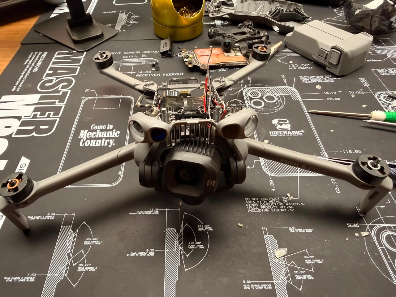 DJI Mini 5 Pro desarmado en el taller de TECDJI PERÚ durante una recuperación tras impacto, con la placa principal fuera del equipo